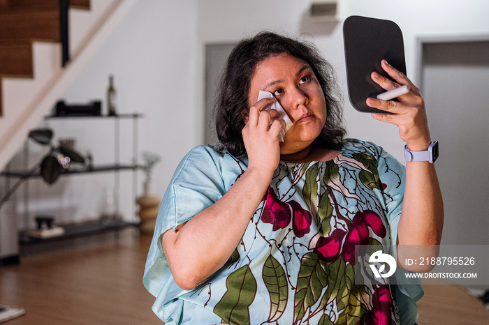 Plus size female removing her make up with a make up wipe