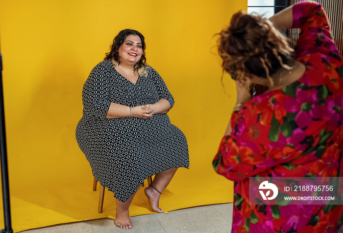 Plus sized female getting her headshots taken by a south asian female photographer