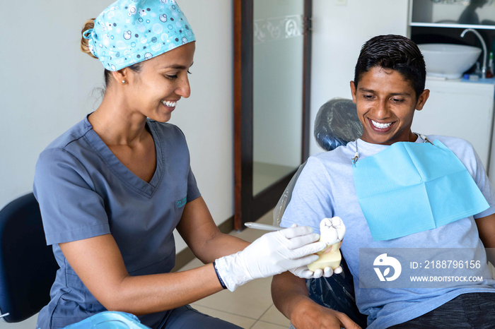 Young dentist explaining to a patient in the dental studio.