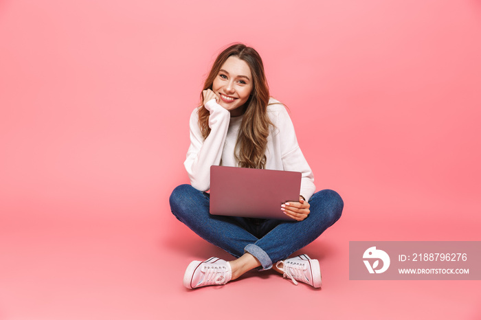 Portrait of a smiling young woman sitting with legs crossed