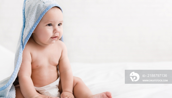 Cute little baby boy in hooded towel after bath