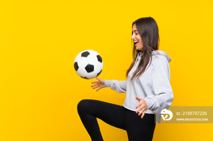 Young football player woman over isolated yellow background