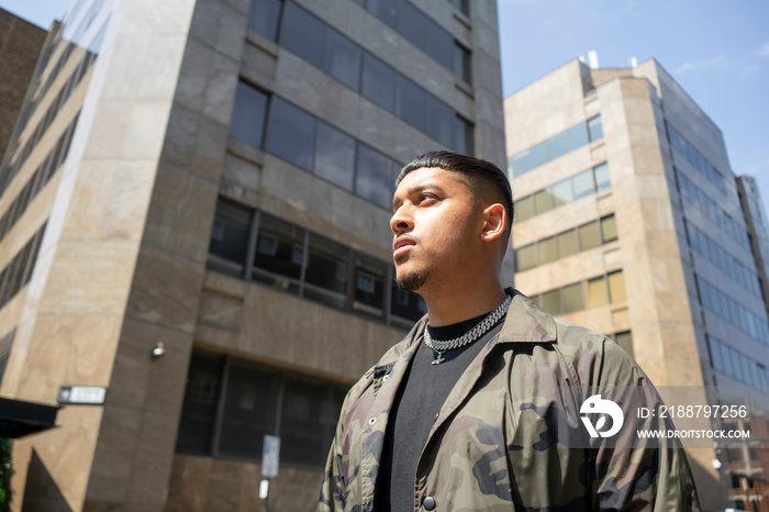 Young man wearing camouflage jacket,black tshirt and necklace