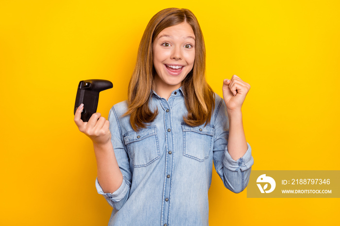 Photo of hooray teenager brown hairdo girl playstation hand fist wear denim shirt isolated on bright yellow color background