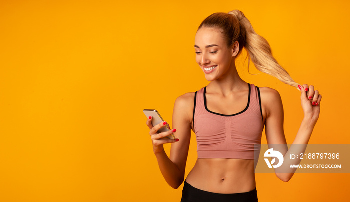 Sporty Woman Using Cellphone During Training Standing Over Yellow Background