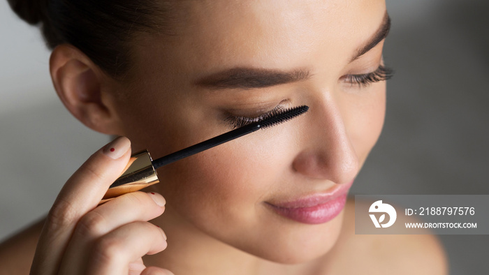 Woman Applying Black Mascara on Eyelashes with Makeup Brush