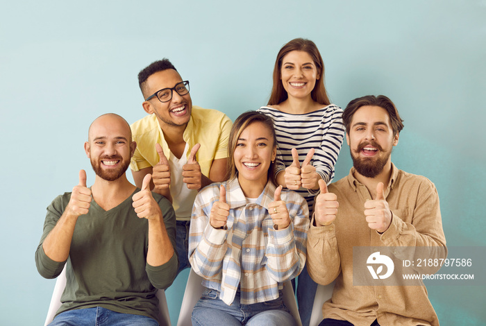 Five confident young people looking at camera and giving thumbs up. Diverse group of smiling male and female college students showing like gesture. Team of girls and guys happy about education success