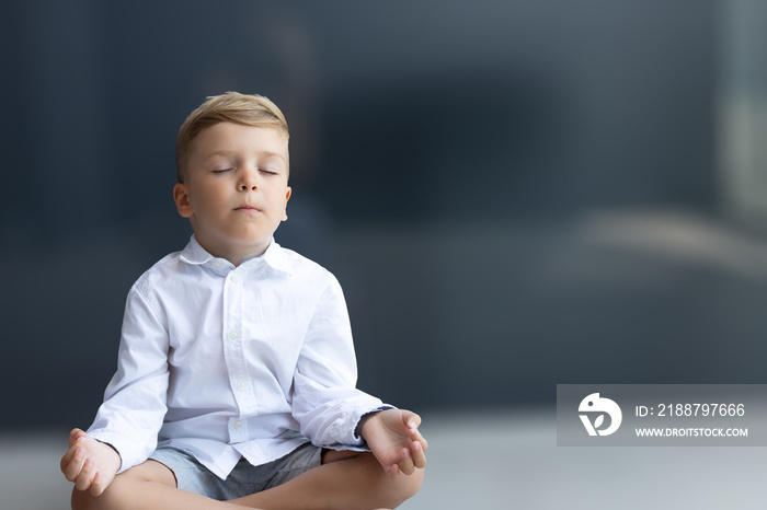 Zen-like boy meditating with eyes closed.