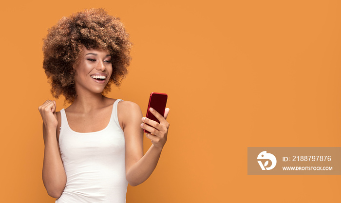 Cheerful afro woman using smart phone.