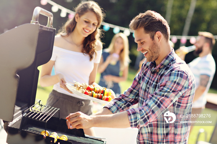 Friends having barbecue party in backyard