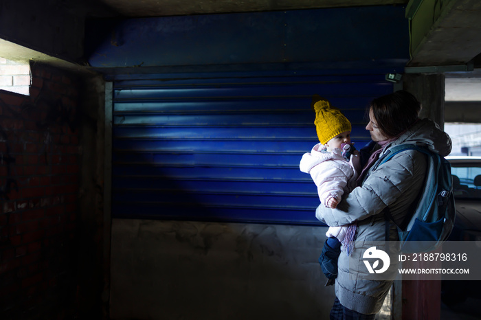 A mother holding her baby in an underground bomb shelter