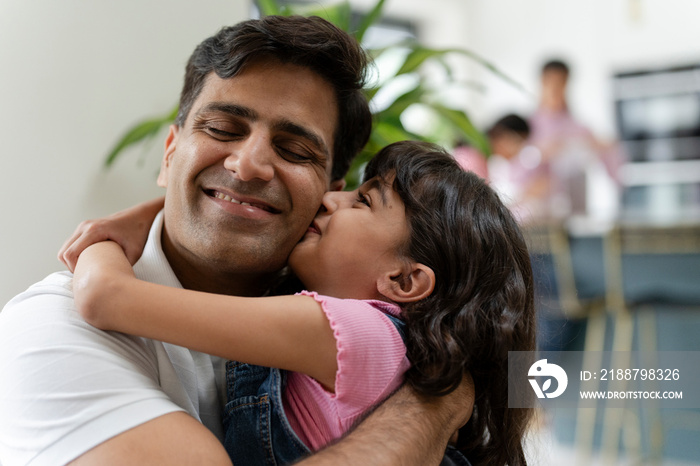 Father hugging daughter at home