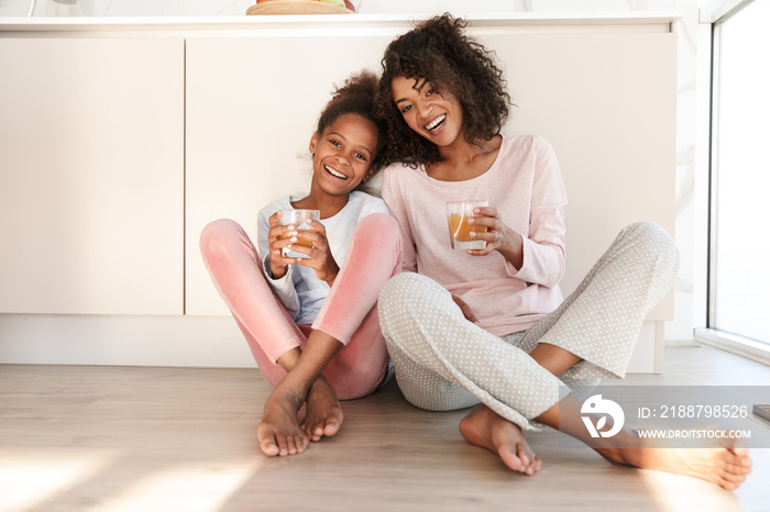 Smiling young mother and her little daughter wearing pajamas