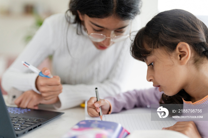 Girl helping little sister doing homework