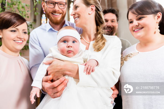 Eltern und Taufzeugen posieren fürs Foto nach der Taufe mit dem Baby und roten Luftballons