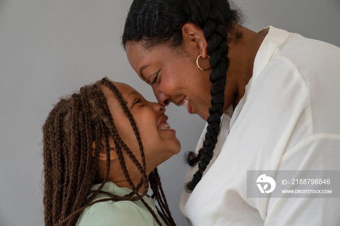 Smiling mother and daughter (6-7) facing each other