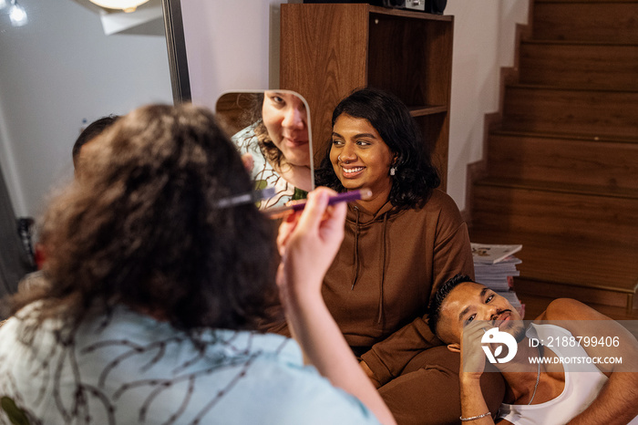 Group of friends doing each others make up at home during a sleepover