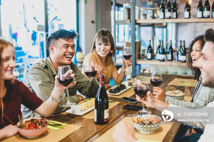 smiling friends at dinner in a restaurant, multiethnic people having fun and drinking red wine, matte filter, millennials lifestyle, celebrate party