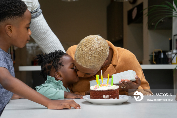 Family with children (2-3, 6-7) celebrating birthday at home