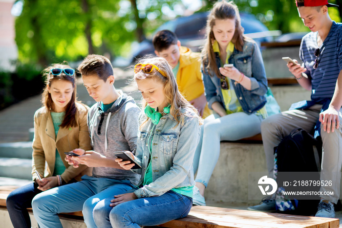 teenage friends with smartphones outdoors