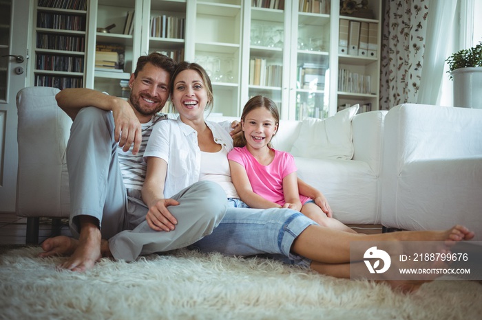 Happy family sitting on the rug in living room