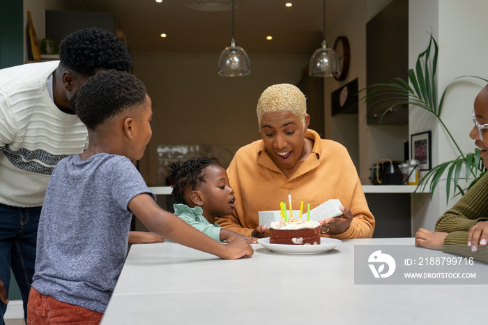 Family with children (2-3, 6-7, 12-13) celebrating birthday at home