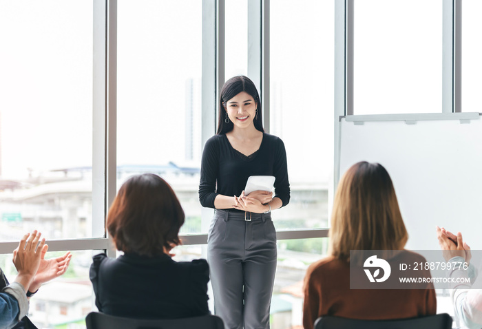 Young business team applauds the Beautiful Asian speaker.