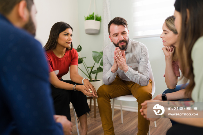 Man in his 30s asking for help at a rehab meeting