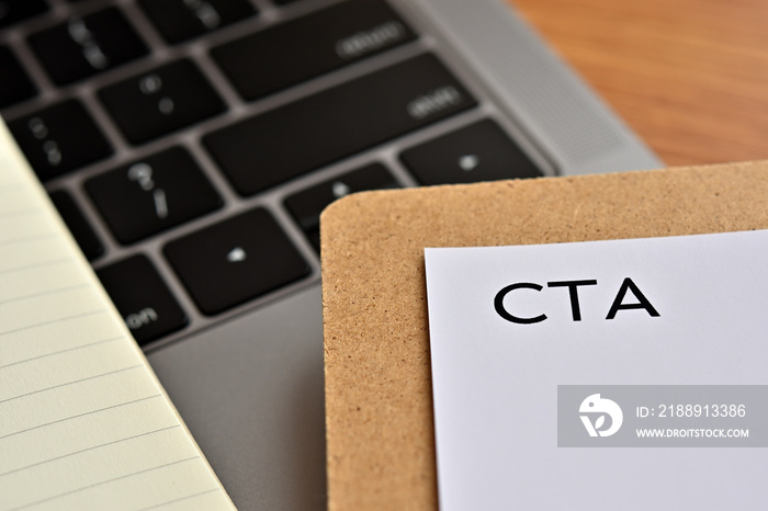 A piece of paper with the word  CTA  written on it sits on the keyboard. Thats an acronym for  Call