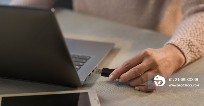 Woman plugging a USB flash drive into her laptop