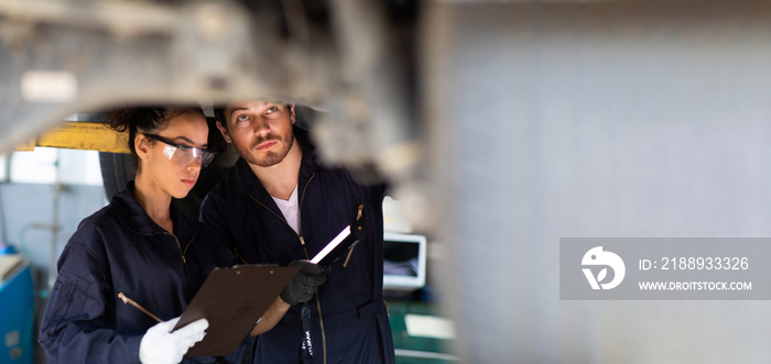 Hispanic Female trainee Mechanics Working Underneath Car Together Car maintenance and auto service g