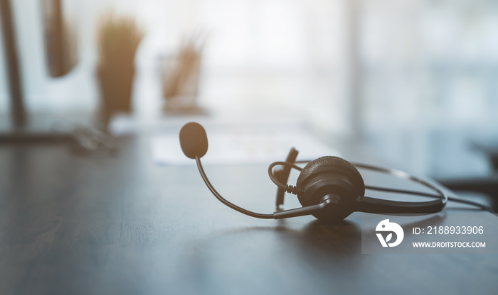 VOIP headset of customer support phone operator at workplace on desk.