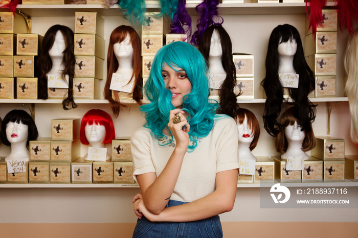 Young woman trying on blue wig