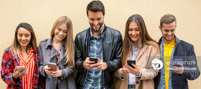 A group of people standing with their smartphones in hand and enjoying online stuff- Friends using c