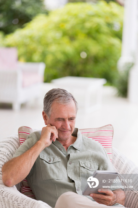 Senior man using digital tablet on patio