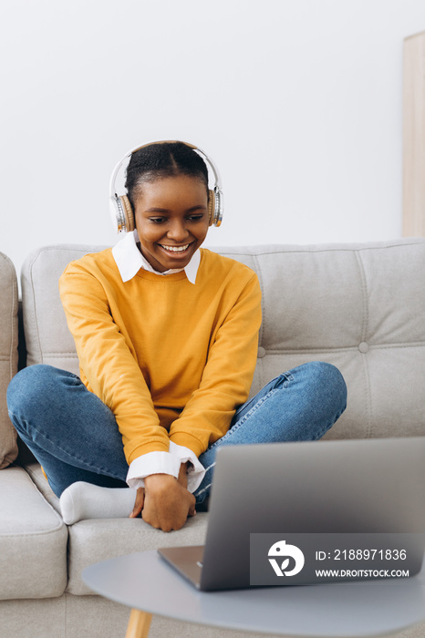 Young African American woman talking on video call in living room at home, distance learning concept