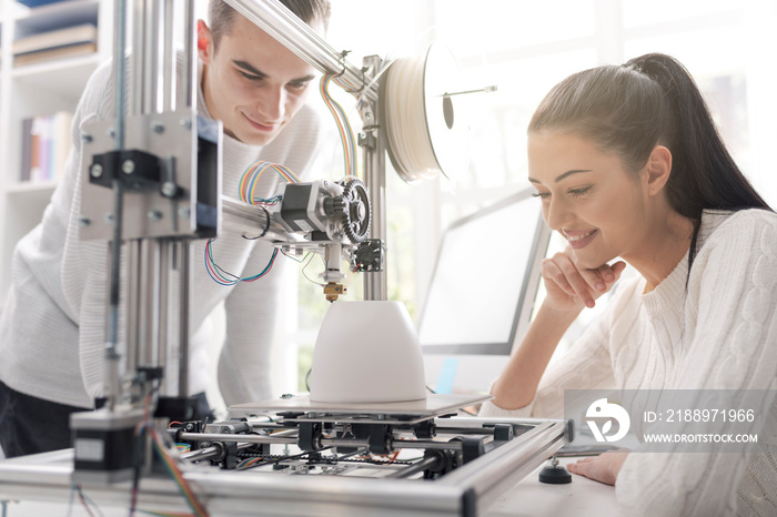 Engineering students using a 3D printer in the lab