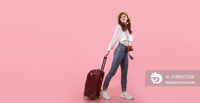 Happy Traveler Girl Posing With Suitcase Standing On Pink Background