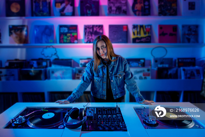 Chica Dj latina mezclando música en una tienda de discos, con un tornamesa y discos de vinil.