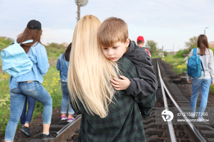 Group of illegal migrants walking along railway tracks