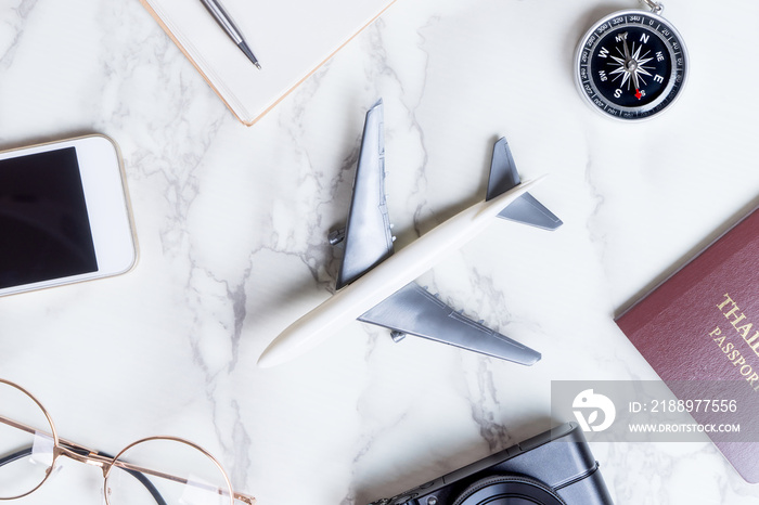 Airplane with travel accessories on marble surface