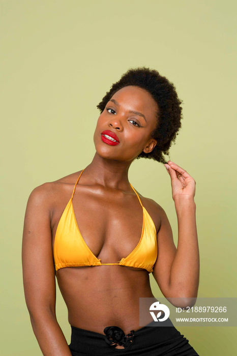 Studio portrait of woman in yellow bikini top