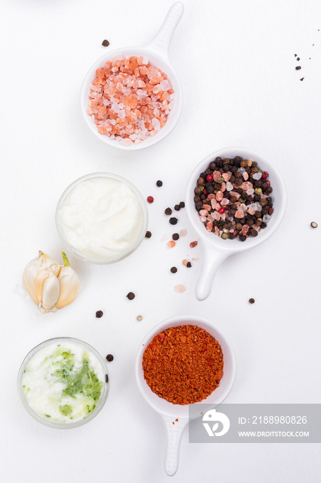 Top view spices salt papper with garlic and white yogurt on white background vertical