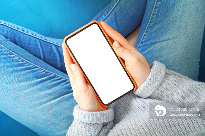 Smartphone with empty screen in a woman hands. Copy space. View above.