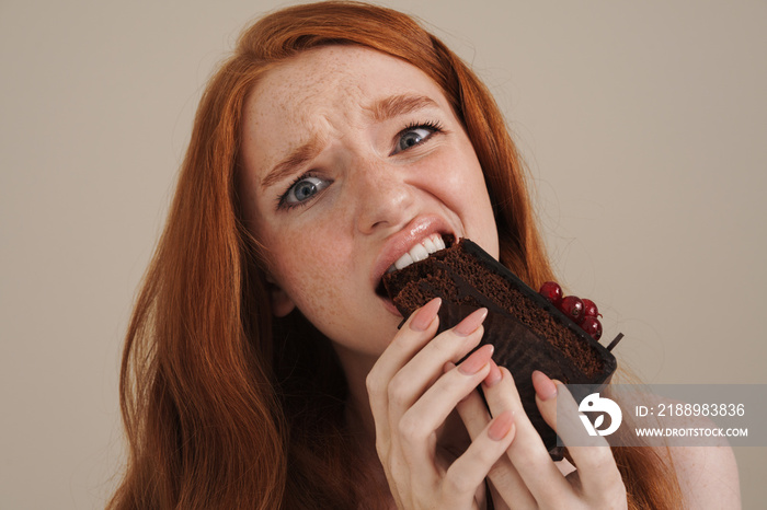 Ginger half-naked scared girl eating chocolate cake