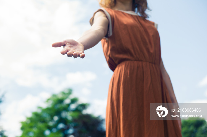 Young woman offering helping hand in nature