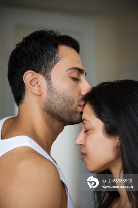 Man kissing his girlfriend on forehead