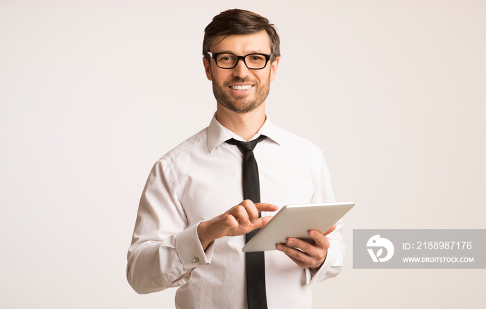 Positive Businessman Using Tablet Standing In Studio