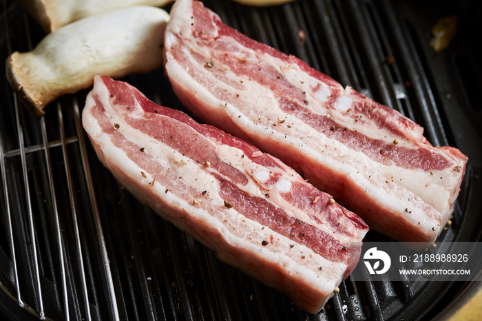 Raw pork belly on the grill