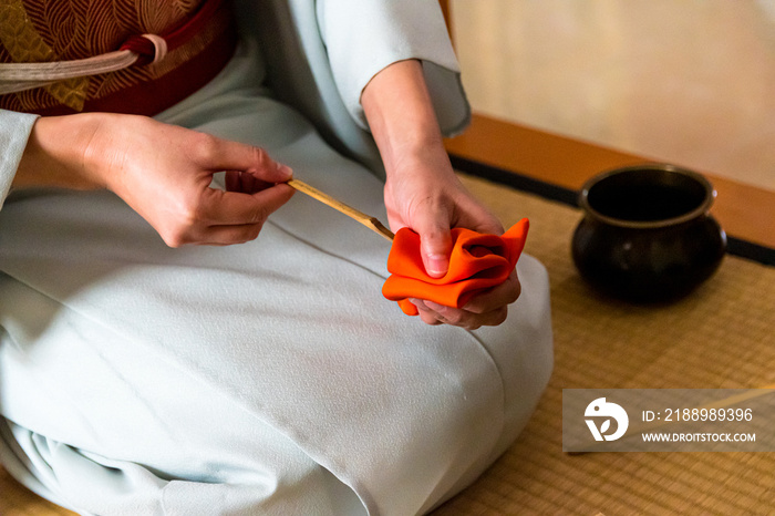 日本女人，茶艺大师，森里圭，用一块橙色的净化布擦拭茶包